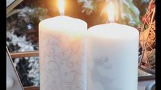 two white candles sitting next to each other