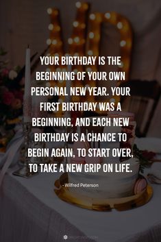 a birthday cake sitting on top of a table next to a lit up sign that says, your birthday is the beginning of your own personal new year