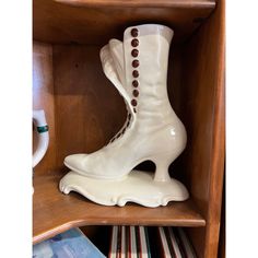 a pair of white shoes sitting on top of a wooden shelf