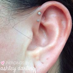 a close up of a person's ear with two piercings