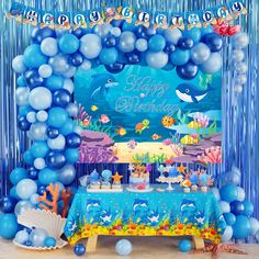 an under the sea themed birthday party with balloons and streamers in blue, white and silver colors