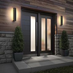 the front door to a house with two potted plants and lights on either side