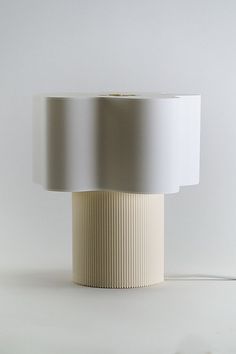 a lamp that is on top of a white surface with a cord attached to it