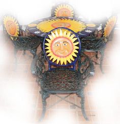 an artisticly designed table and chairs with sun faces on them