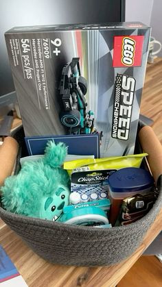 a stuffed animal in a basket filled with toys and other items sitting on a desk