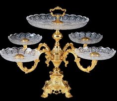 an ornately decorated gold and silver candelabra with glass plates on it