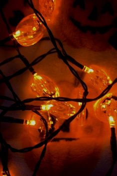 some orange lights are on the ground with jack - o'- lantern faces