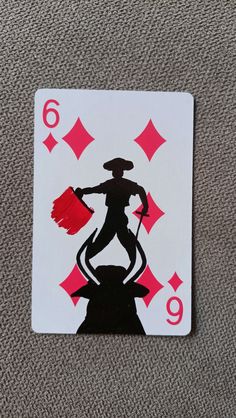 a playing card with the silhouette of a man holding a paintbrush and wearing a top hat