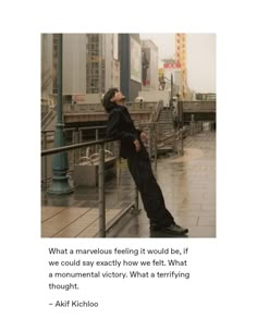 an image of a man leaning on a railing in the rain with his head down