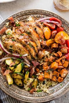 a bowl filled with chicken, vegetables and rice