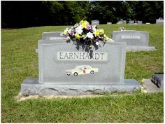 a headstone with flowers on it in the grass next to other headstones that say earnhanddt