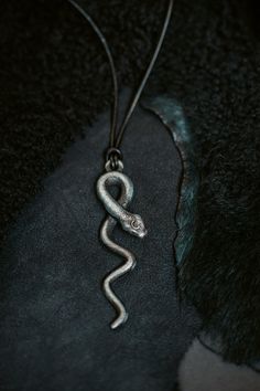 Introducing the exquisite Lilith Goddess Snake Pendant, a captivating piece of jewelry that beautifully combines mythology and craftsmanship. This unique pendant is a stunning homage to the enigmatic figure of Lilith, intricately designed to reflect her symbolic power and allure. Crafted from nickel patina, this pendant features a meticulously detailed snake, elegantly coiled and poised for action. The snake, a potent symbol of transformation and wisdom, embodies the essence of Lilith herself. I Spiritual Brass Snake-shaped Jewelry, Spiritual Snake Shape Necklace As Gift, Hand Forged Spiritual Jewelry For Larp, Spiritual Brass Jewelry In Snake Shape, Unique Brass Snake Jewelry, Lilith Jewelry, Spiritual Snake-shaped Metal Jewelry, Symbolic Snake-shaped Brass Jewelry, Spiritual Metal Jewelry In Snake Shape