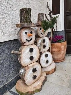 there are snowmen made out of logs on the side of a building with plants in them