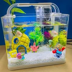 an aquarium filled with fish and plants on top of a table