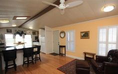 a living room filled with furniture next to a kitchen and dining room table in front of a bar