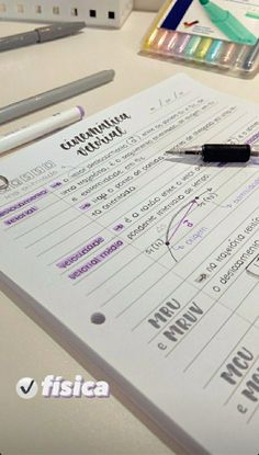 a pen sitting on top of a piece of paper next to some markers and pens