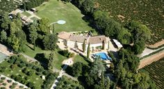 an aerial view of a large estate surrounded by trees and bushes with a pool in the middle