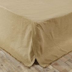 a bed with a tan bedspread on top of it