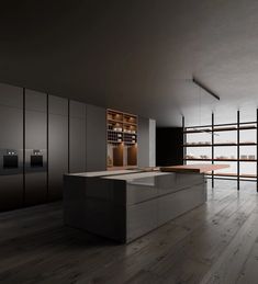 an empty kitchen with wooden floors and black cabinets