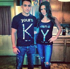 a man and woman standing next to each other in front of a refrigerator wearing t - shirts that say yours khne