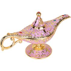 a pink and gold teapot on a stand with a magnifying glass in it