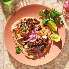 a pink plate topped with food and garnished with cilantro