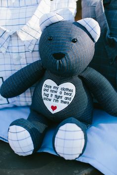 a black teddy bear sitting on top of a blue pillow