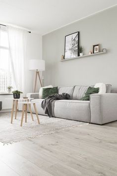 a living room with white walls and wood floors