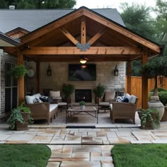 an outdoor living area with couches, chairs and a fireplace in the middle of it