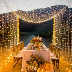 an outdoor dining table with candles and lights