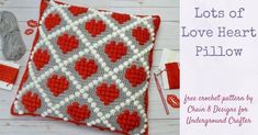 a crocheted pillow with red hearts on it and the words lots of love heart pillow