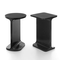 two black pedestals on white background with one standing up and the other sitting down