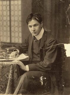 an old black and white photo of a man sitting in a chair with a book