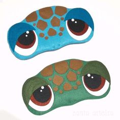 two handmade eye cushions with different colored eyes on white background, one is green and the other is blue