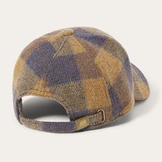 a brown and blue plaid hat with a gold buckle on the front, sitting against a white background