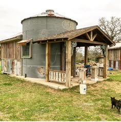 a dog standing in front of a building with a water tank on it's roof