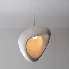 a white light fixture hanging from a ceiling in a room with grey walls and flooring