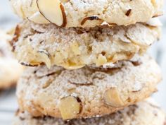 several cookies stacked on top of each other with powdered sugar and almonds in the middle