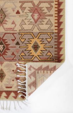 two rugs with different colors and patterns on the floor, one has a fringed edge