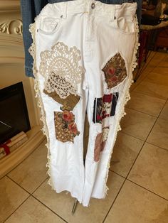 a pair of white jeans with patches on them