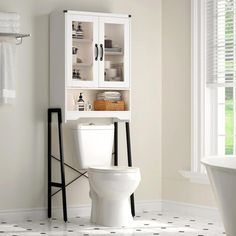 a white toilet sitting in a bathroom next to a bath tub