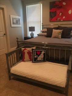 a bedroom with a metal bed frame and pillows on the bottom half of the bed