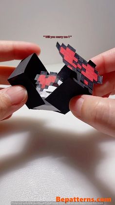 two hands holding an origami piece with the shape of a man's head