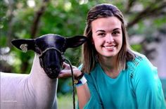 a young woman is petting a black and white sheep