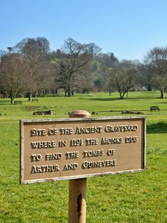 a sign in the middle of a grassy field that says site of the ancient graveyard where in 1911 the monks pug to find the stones of athun and cunvene