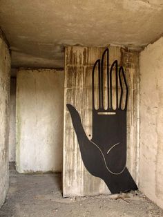 a large hand painted on the side of a wall in an unfinished room with concrete walls