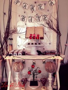 a table topped with candles and decorations on top of a white shelf next to a window