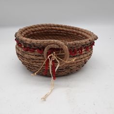 a woven basket with red tassels on it