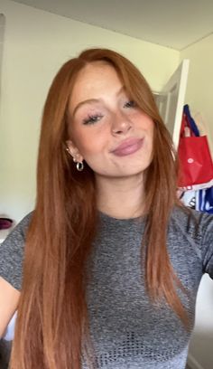 a woman with long red hair is taking a selfie