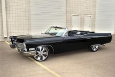 an old black car parked in front of a building